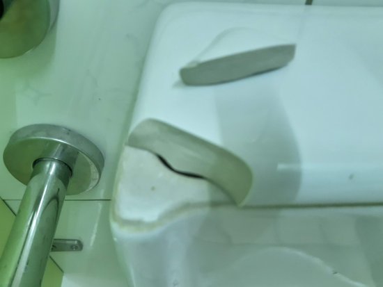 特教班旁西側一樓廁所小便斗上方瓷製蓋板部分斷裂
